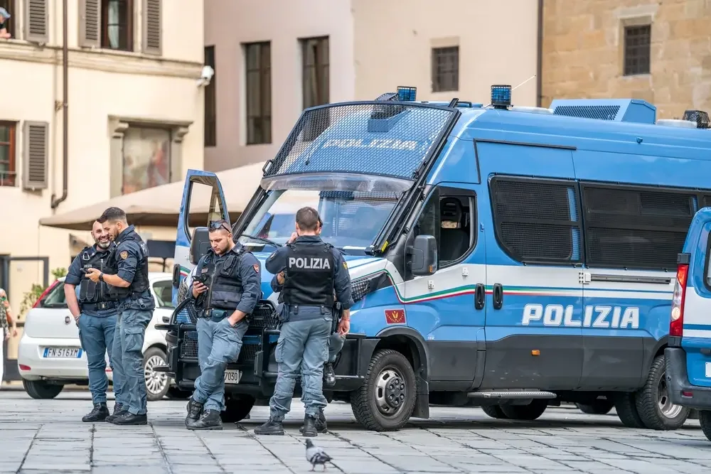 Agenti della Polizia di Stato accanto ai furgoni di servizio in una piazza di Firenze