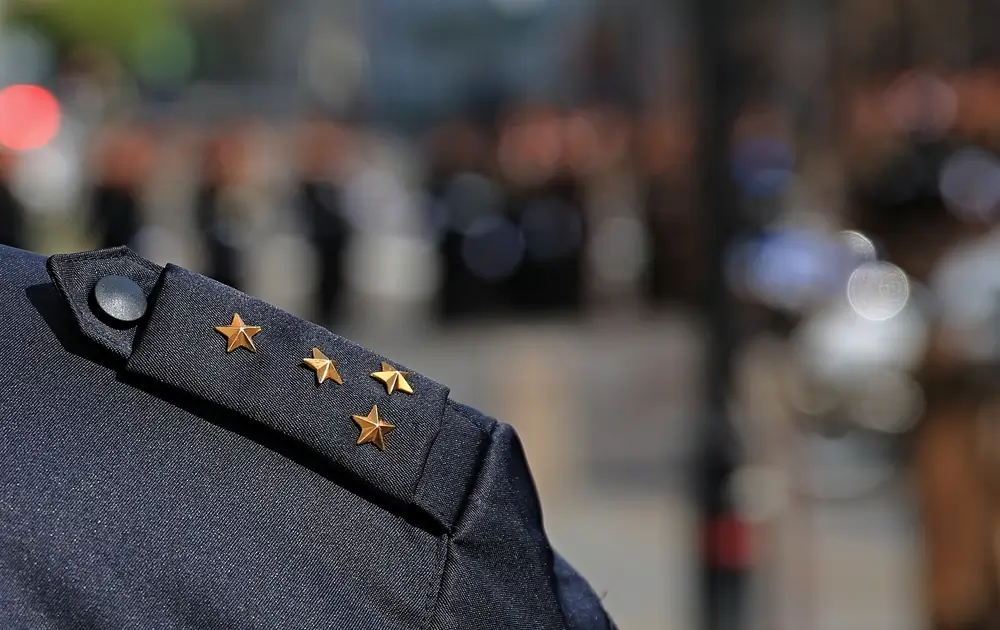 Dettaglio dei gradi e mostrine con stelle dorate sulla spallina di un'uniforme della Polizia di Stato.