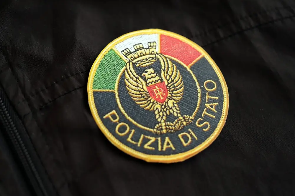 Stemma della Polizia di Stato ricamato in primo piano su una giacca scura della divisa operativa.