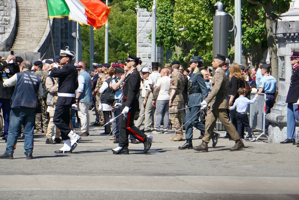 Ufficiali in divisa da cerimonia con sciabole e bandiera italiana durante una parata istituzionale delle forze dell'ordine.