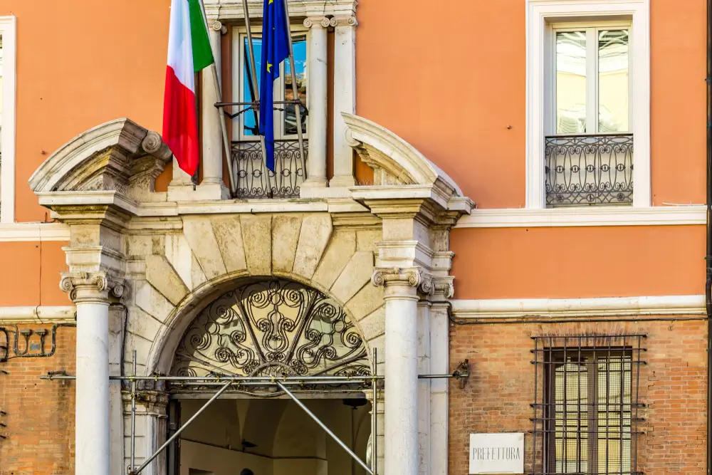 Ingresso di un edificio istituzionale con bandiere, sede di prefettura o questura per i concorsi nella Polizia di Stato.