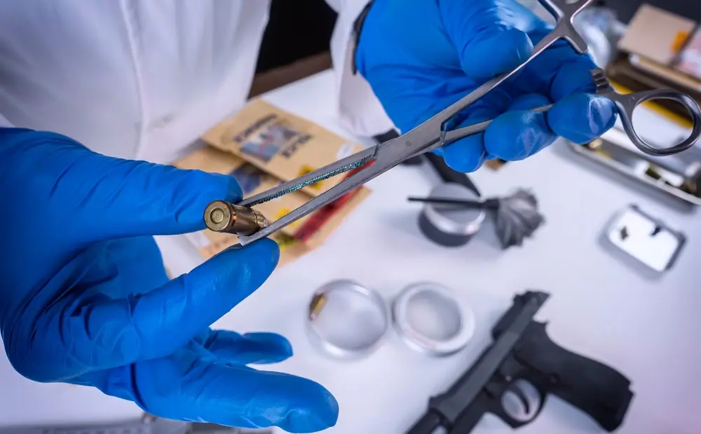 Analisi di un bossolo in un laboratorio della Polizia Scientifica con strumenti di precisione per indagini forensi.
