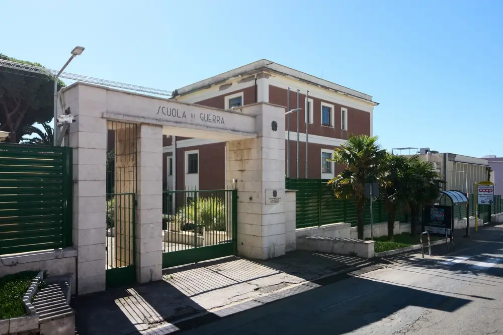 Facciata di un moderno edificio della scuola di polizia con cancello d'ingresso in pietra e mura in mattoni rossi.