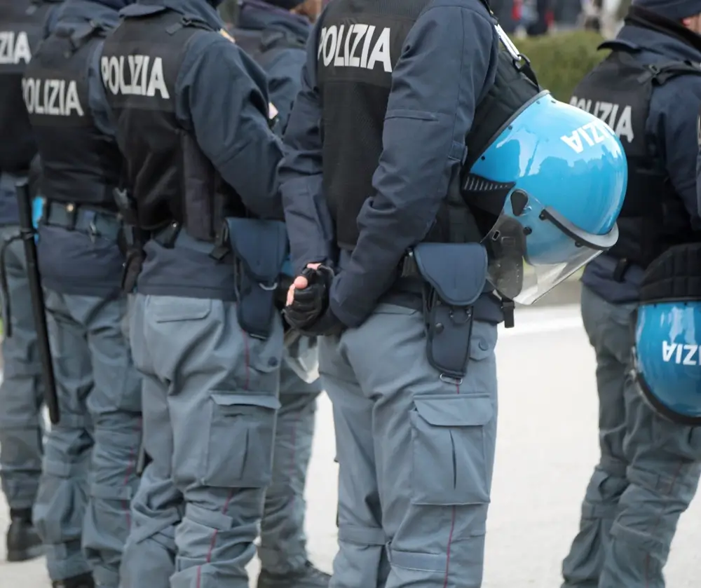 Agenti della Polizia di Stato in divisa tattica e caschi blu schierati presso una sede operativa della questura.