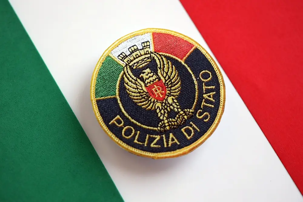 Stemma della Polizia di Stato su sfondo tricolore, simbolo della gerarchia e dei livelli di carriera per le promozioni.