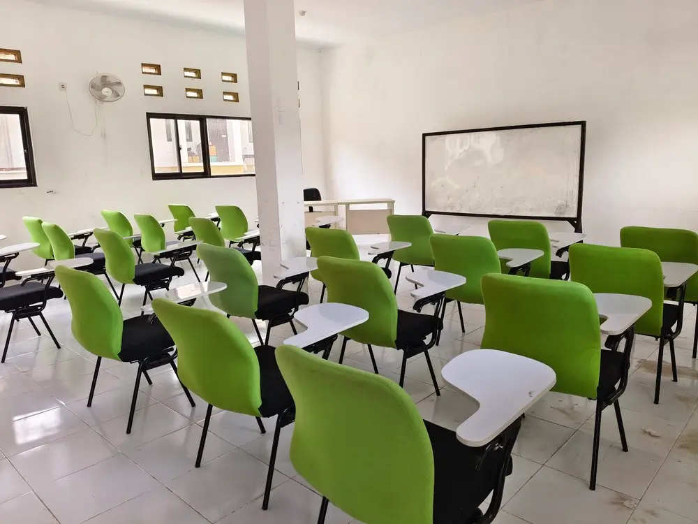 Aula moderna della Scuola Superiore di Polizia con sedie verdi e lavagna per la formazione dei nuovi funzionari.